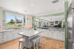 Experience the best of indoor-outdoor living in this stunning kitchen, featuring a large island with seating and ample counter space.
