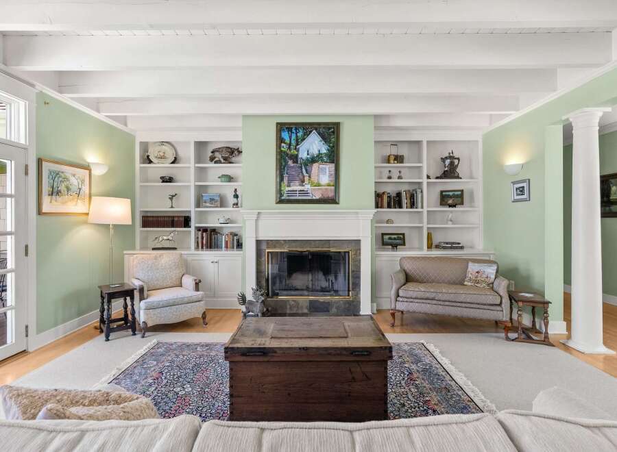 Step into this inviting living room, bathed in natural light and featuring a charming fireplace as its centerpiece.