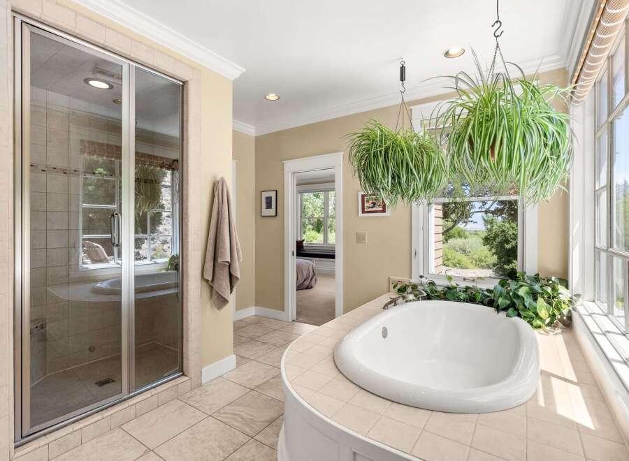 Indulge in relaxation in this luxurious bathroom featuring a spacious soaking tub with a scenic view.