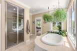 Indulge in relaxation in this luxurious bathroom featuring a spacious soaking tub with a scenic view.