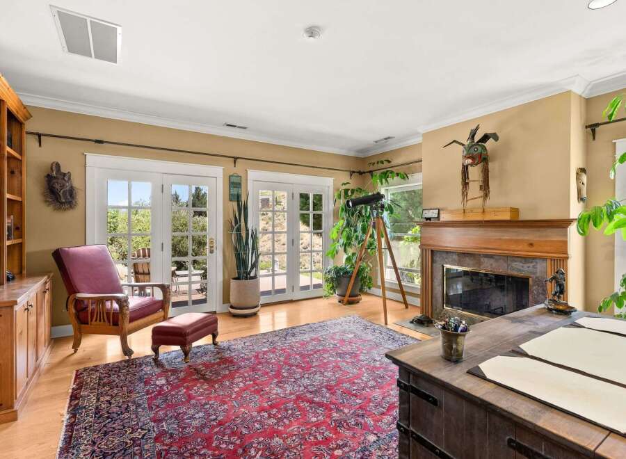 Step into this inviting living space featuring a cozy reading nook with a plush armchair and ottoman, perfect for quiet afternoons.