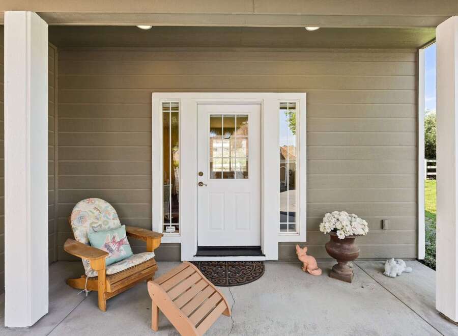 Welcome guests to this charming home with a covered front porch, perfect for enjoying your morning coffee.