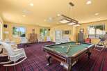 Enjoy endless entertainment in this spacious game room, featuring a classic pool table perfect for friendly competitions.
