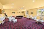 This spacious recreation room offers a perfect blend of entertainment and relaxation, featuring a full-size pool table for friendly games and comfortable wicker seating areas for guests to unwind.