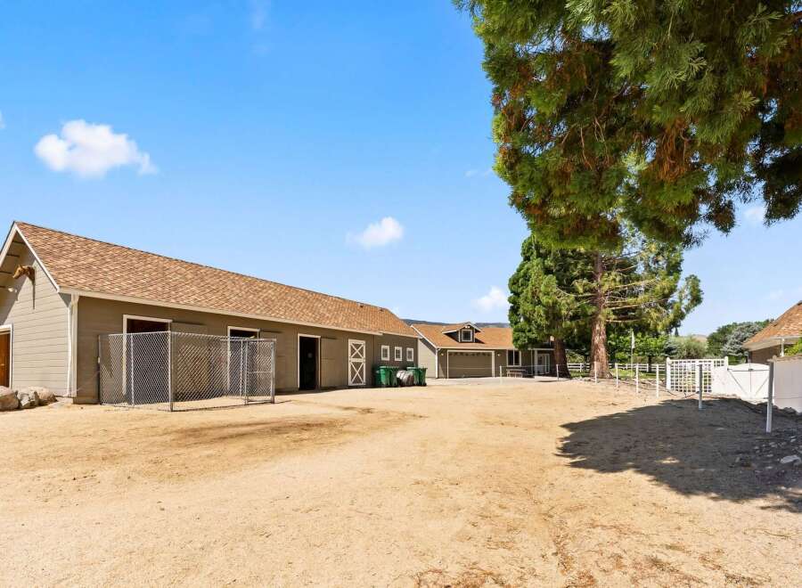 Discover this charming equestrian property featuring a spacious barn with multiple stalls and ample storage.