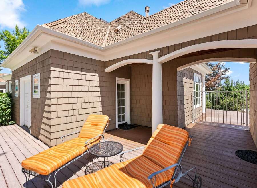 Relax and unwind on this beautiful wooden deck, featuring two comfortable lounge chairs perfect for soaking up the sun.