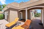 Relax and unwind on this beautiful wooden deck, featuring two comfortable lounge chairs perfect for soaking up the sun.