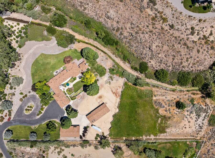 Discover this expansive property featuring a charming main residence with a tile roof and a beautifully landscaped courtyard.