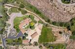 Discover this expansive property featuring a charming main residence with a tile roof and a beautifully landscaped courtyard.