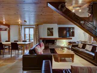 Experience rustic charm in this inviting living space, featuring a cozy fireplace and a spacious dining area perfect for family gatherings.