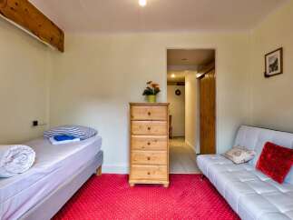 Discover this charming room featuring a comfortable single bed with rolled duvet and striped pillows, perfect for a restful night's sleep.