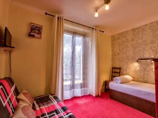 This charming hotel room features a comfortable sofa bed with a vibrant geometric pattern, perfect for relaxing after a day of exploring.