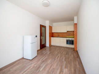 Discover this charming studio apartment featuring a compact kitchen with modern appliances and a brick accent wall.