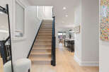 Step into this stunning home featuring a modern staircase with light wood treads and a sleek black railing.