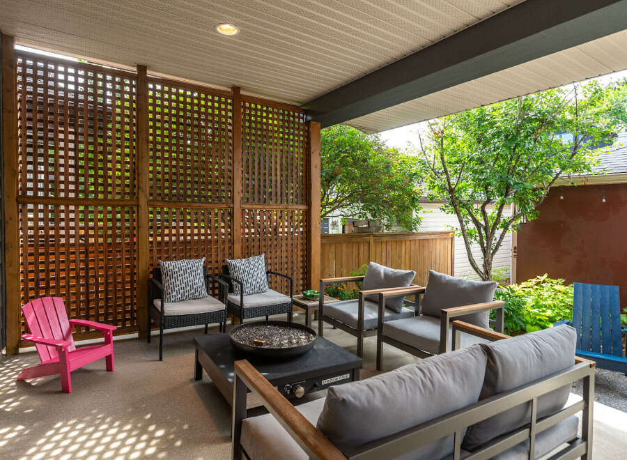 Enjoy outdoor living in this covered patio space, featuring a modern fire pit and comfortable seating arrangements.