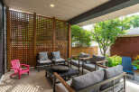 Enjoy outdoor living in this covered patio space, featuring a modern fire pit and comfortable seating arrangements.