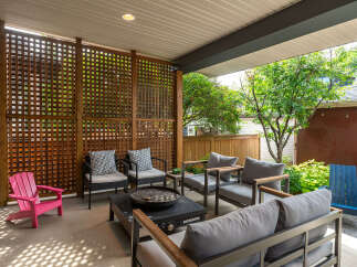 Enjoy outdoor living in this covered patio space, featuring a modern fire pit and comfortable seating arrangements.