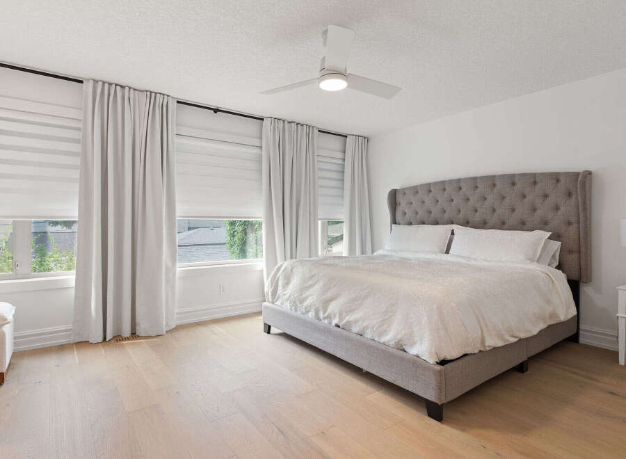 Experience ultimate comfort in this master bedroom, featuring a luxurious tufted headboard and plush bedding.