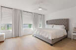 Experience ultimate comfort in this master bedroom, featuring a luxurious tufted headboard and plush bedding.