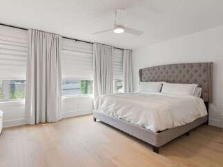 Experience ultimate comfort in this master bedroom, featuring a luxurious tufted headboard and plush bedding.