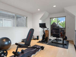 Elevate your fitness routine in this dedicated home gym, featuring a versatile weight bench, a Peloton bike, and a comprehensive weight machine.