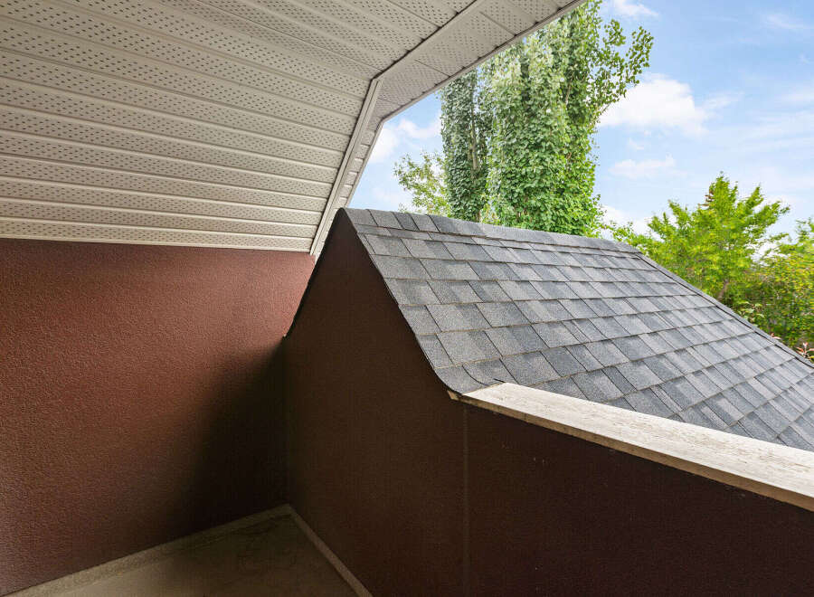 Discover the architectural details of this property, featuring a classic asphalt shingle roof that complements the textured brown exterior walls.