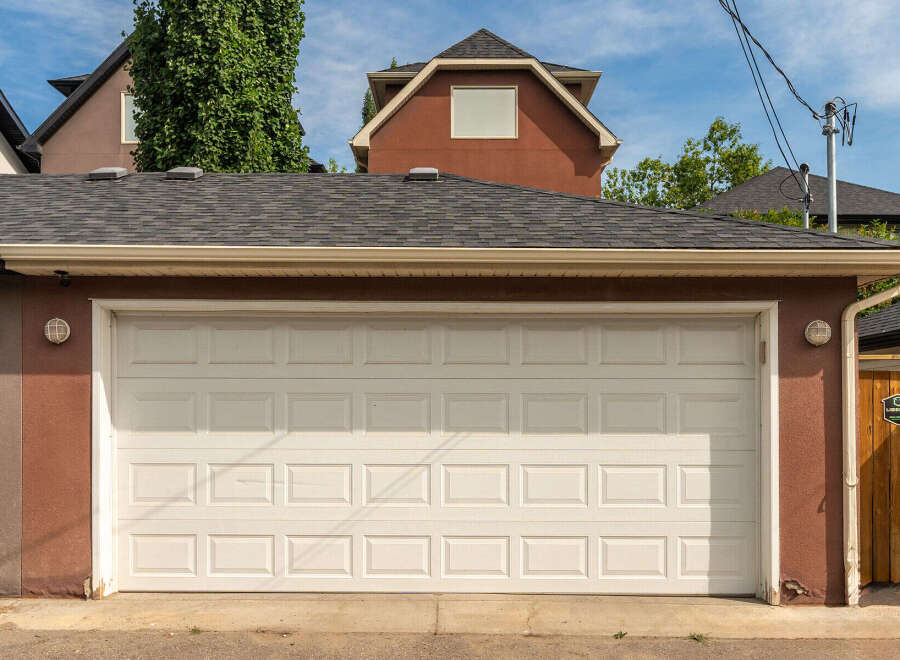 This property features a well-maintained garage with a classic white sectional door, perfect for securing your vehicles.