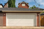 This property features a well-maintained garage with a classic white sectional door, perfect for securing your vehicles.