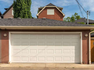 This property features a well-maintained garage with a classic white sectional door, perfect for securing your vehicles.