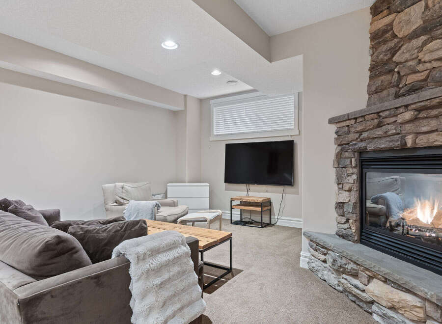 Cozy up by the stunning stone fireplace in this inviting living space, perfect for relaxation and entertainment.