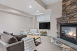 Cozy up by the stunning stone fireplace in this inviting living space, perfect for relaxation and entertainment.