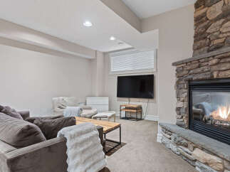 Cozy up by the stunning stone fireplace in this inviting living space, perfect for relaxation and entertainment.