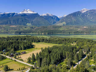 Discover your dream home nestled amidst breathtaking mountain scenery and a serene lake.