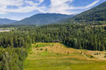 Discover an expansive rural property nestled amidst a lush, green forest and rolling meadows.