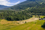 Discover this expansive property nestled amidst a lush forest and rolling hills, offering breathtaking mountain views.