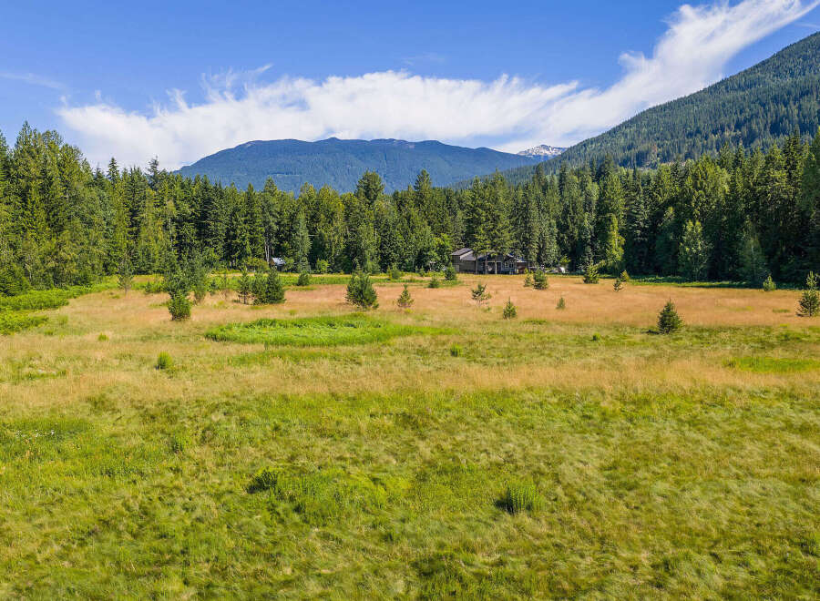 Discover serene living in this picturesque property, nestled amidst a lush forest and expansive meadow.