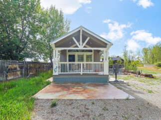 Charming tiny home with a welcoming front porch, perfect for enjoying the outdoors.