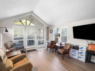 Step into this inviting living room featuring a vaulted ceiling with a unique triangular window, bringing in abundant natural light.