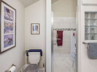 This bathroom features a modern shower with white tiled walls and a decorative mosaic tile accent.