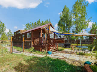 Discover this charming tiny home nestled amidst mature trees, offering a serene escape.