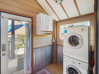 This charming laundry area features a stacked washer and dryer, perfect for maximizing space in a compact home.