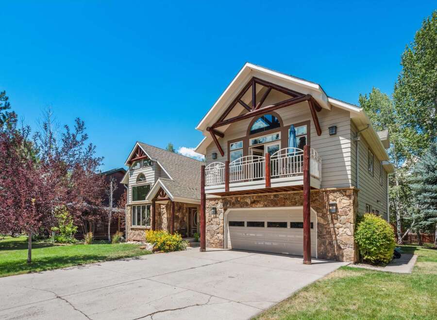 Experience mountain living in this stunning home featuring a striking stone and wood exterior, perfect for a rustic aesthetic.