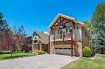 Experience mountain living in this stunning home featuring a striking stone and wood exterior, perfect for a rustic aesthetic.