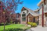 Experience mountain living in this charming home featuring a striking stone facade and rustic wooden accents.