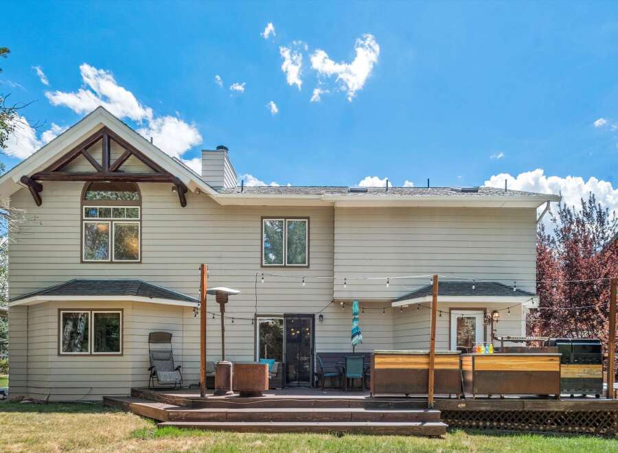 Enjoy outdoor living with this spacious deck featuring a hot tub and a built-in grill, perfect for entertaining guests.
