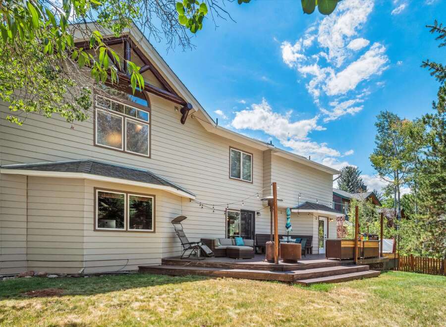 Enjoy outdoor living with this spacious deck featuring a sectional sofa, patio heater, and string lights, perfect for entertaining.