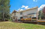 Enjoy outdoor living with this spacious deck featuring a hot tub, grill, and ample seating areas perfect for entertaining.