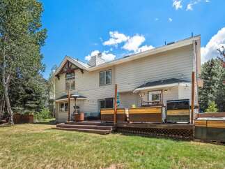 Enjoy outdoor living with this spacious deck featuring a hot tub, grill, and ample seating areas perfect for entertaining.