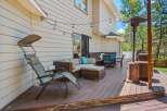 Enjoy outdoor living on this spacious deck featuring a comfortable sectional sofa, dining set, and a relaxing lounge chair.