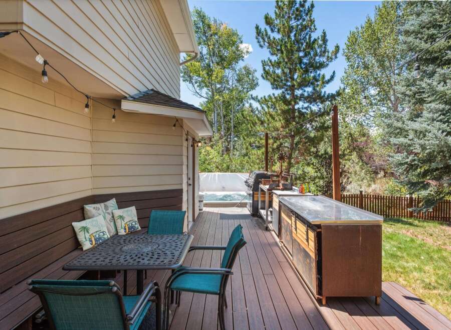 Enjoy outdoor living at its finest on this spacious deck, complete with a dining set, a built-in grill station, and a relaxing hot tub.
